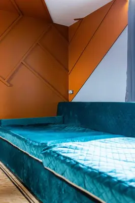 a bed in a room with an orange wall at The Luxury Penthouse by Sasco Apartments in Blackpool