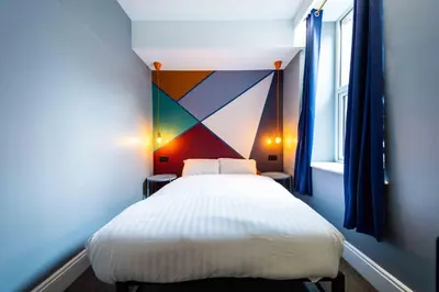a bedroom with a white bed with a colorful headboard at The Luxury Penthouse by Sasco Apartments in Blackpool
