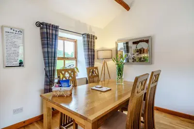 a dining room with a wooden table and chairs at Ingleborough View in Carnforth