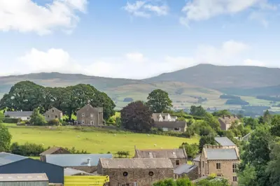 a small village with mountains in the background at Ingleborough View in Carnforth