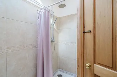 a bathroom with a shower with a pink shower curtain at Ingleborough View in Carnforth