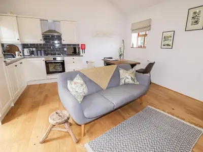 a living room with a couch and a kitchen at The Stables in Preston