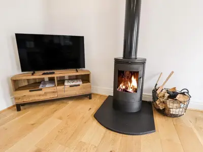 a fireplace in a living room with a tv at The Stables in Preston
