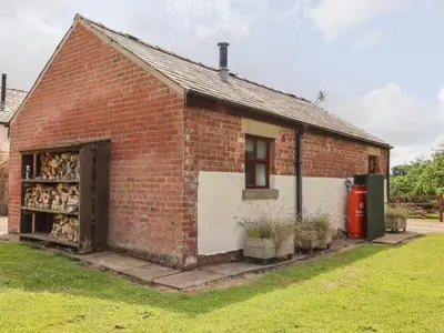a red brick building with a garage at The Stables in Preston