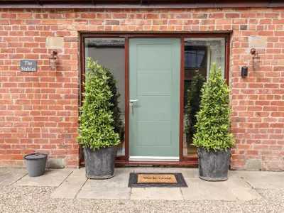 three potted plants sitting in front of a door at The Stables in Preston