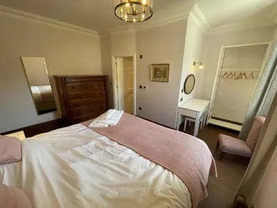 a bedroom with a bed and a dresser and a chair at Victoria Mount in Grange Over Sands