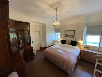 a bedroom with a bed and a chandelier at Victoria Mount in Grange Over Sands