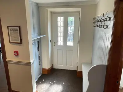a hallway with a white door and a window at Victoria Mount in Grange Over Sands