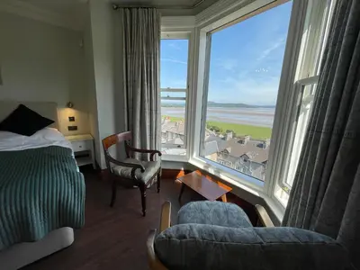 a bedroom with a bed and a large window at Victoria Mount in Grange Over Sands