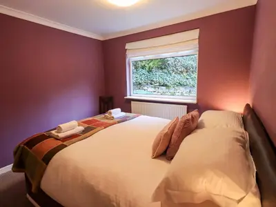 a bedroom with a bed and a window at Yewbarrow Cottage in Grange Over Sands
