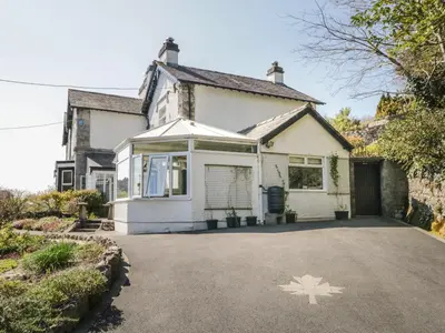 a white house with a maple leaf painted on the driveway at Yewbarrow Cottage in Grange Over Sands