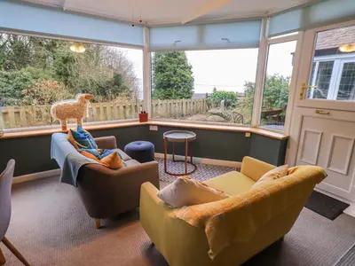 a living room with two couches and a large window at Yewbarrow Cottage in Grange Over Sands
