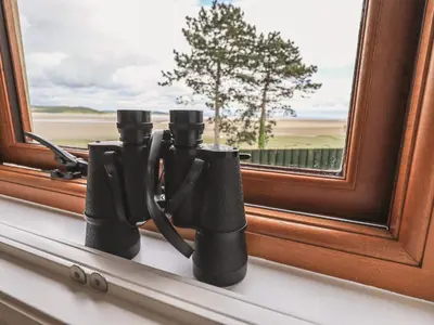 a group of binoculars sitting on a window sill at Oversands Cottage in Grange Over Sands