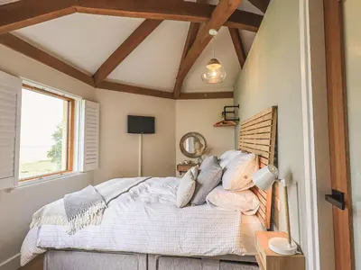 a bedroom with a bed and a window at Oversands Cottage in Grange Over Sands