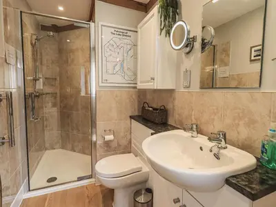 a bathroom with a sink and a shower and a toilet at Oversands Cottage in Grange Over Sands