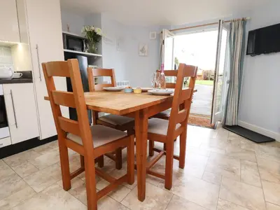 a kitchen with a wooden table and chairs in a kitchen at Inglewood Court in Carnforth