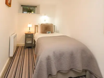 a bedroom with a bed and a table with a lamp at Inglewood Court in Carnforth