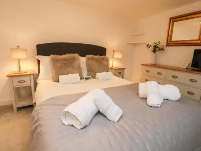 a bedroom with a bed with towels on it at Inglewood Court in Carnforth