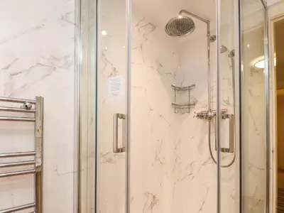 a shower in a bathroom with white marble at Inglewood Court in Carnforth