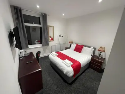 a bedroom with a bed and a television in it at PCK THAS HOTEL in Blackpool