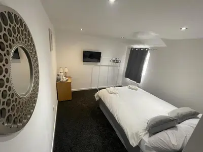 a bedroom with a bed and a large mirror at PCK THAS HOTEL in Blackpool