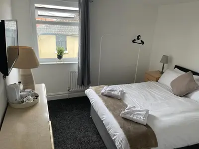 a bedroom with a white bed and a window at PCK THAS HOTEL in Blackpool