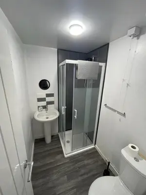 a bathroom with a shower and a toilet and a sink at PCK THAS HOTEL in Blackpool