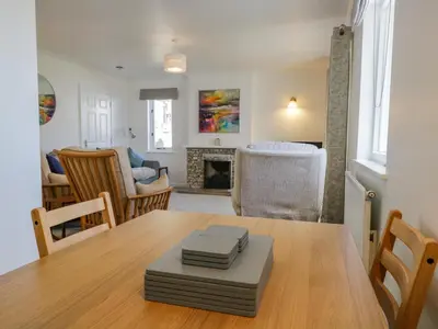 a dining room with a table and a living room at Westwinds in Grange Over Sands