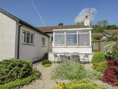 a house with a table and chairs in a yard at Westwinds in Grange Over Sands