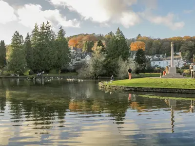a body of water with a person standing next to a lake at Westwinds in Grange Over Sands