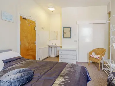 a bedroom with a bed and a bathroom with a sink at Highbury in Blackpool