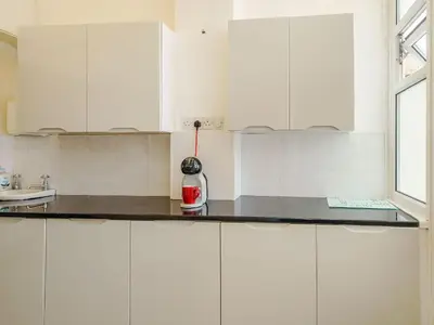 a kitchen with white cabinets and a counter top at Highbury in Blackpool