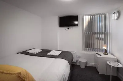 a bedroom with a bed and a tv on the wall at Jellyfish Apartments in Blackpool