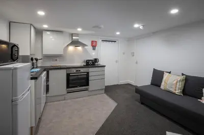 a living room with a couch and a kitchen at Jellyfish Apartments in Blackpool