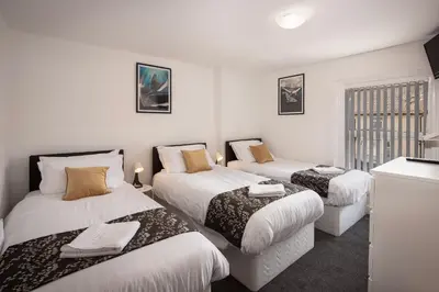 three beds in a room with white walls at Jellyfish Apartments in Blackpool
