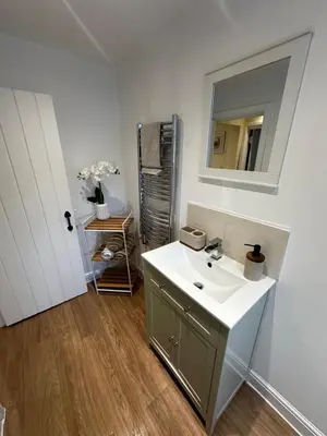a bathroom with a sink and a mirror at Whitebrook Cottage in Mellor