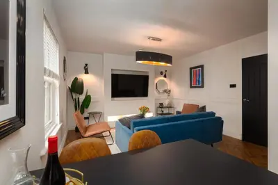 a living room with a blue couch and a table at Capri Stays - Apartment Two - Two Bed Apartment in Blackpool