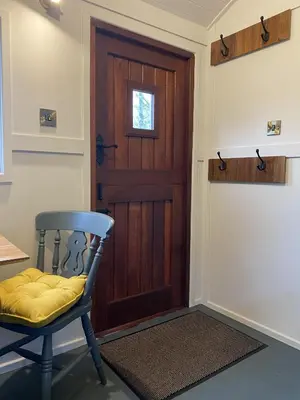 a room with a wooden door and a chair at Heywood Glamping in Ormskirk