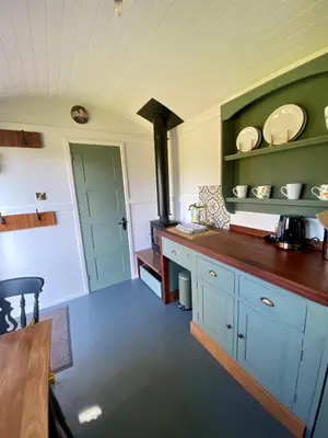 a kitchen with blue cabinets and a stove at Heywood Glamping in Ormskirk
