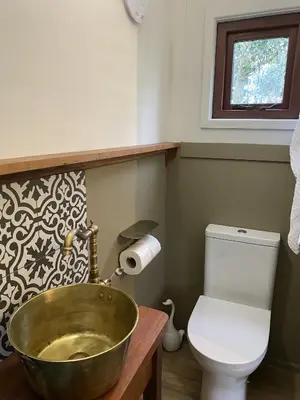 a bathroom with a bowl sink and a toilet at Heywood Glamping in Ormskirk
