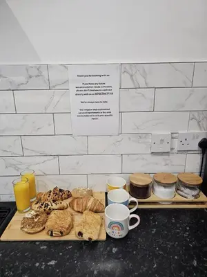 a table with a tray of pastries and cups of coffee at Cheerful 4 bedroom close to Uclan, Preston City Center in Preston
