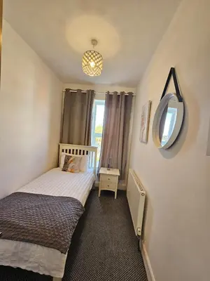 a small bedroom with a bed and a mirror at Cheerful 4 bedroom close to Uclan, Preston City Center in Preston