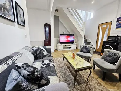 a living room with a couch and a tv at Cheerful 4 bedroom close to Uclan, Preston City Center in Preston