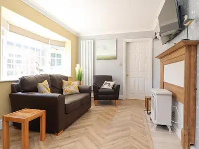 a living room with a couch and a chair at The Mews Cottage in Lytham St Annes