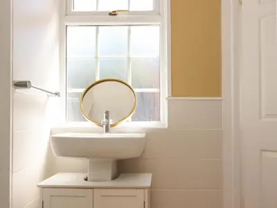 a bathroom with a sink and a mirror at The Mews Cottage in Lytham St Annes