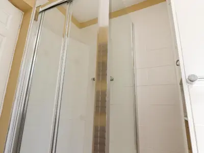 a shower with a glass door in a bathroom at The Mews Cottage in Lytham St Annes