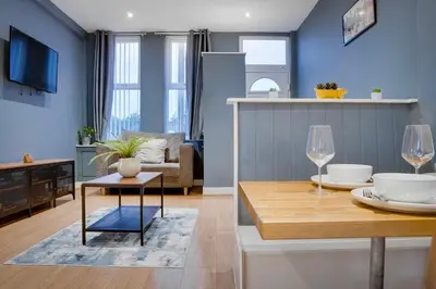 a kitchen and living room with a table and chairs at Birkenhead - 2 bedroom house in Birkenhead