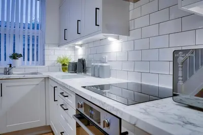 a white kitchen with a sink and a stove at Birkenhead - 2 bedroom house in Birkenhead