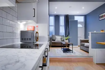 a kitchen and living room with blue walls at Birkenhead - 2 bedroom house in Birkenhead