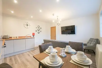 a kitchen and a living room with a table and chairs at The Queens Arms Apartments in Liverpool
